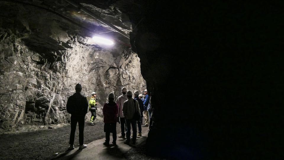 LKAB:s gruva i Kiruna, nära 500 meter under jord. Besökare i nästan totalt mörjker.