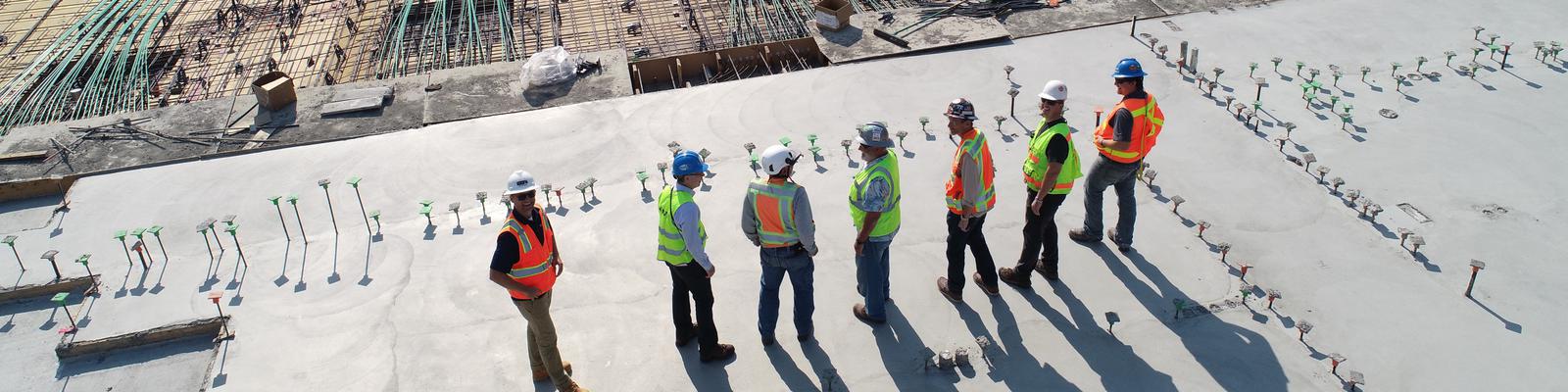 Byggnadsarbetare ser ut över en byggarbetsplats