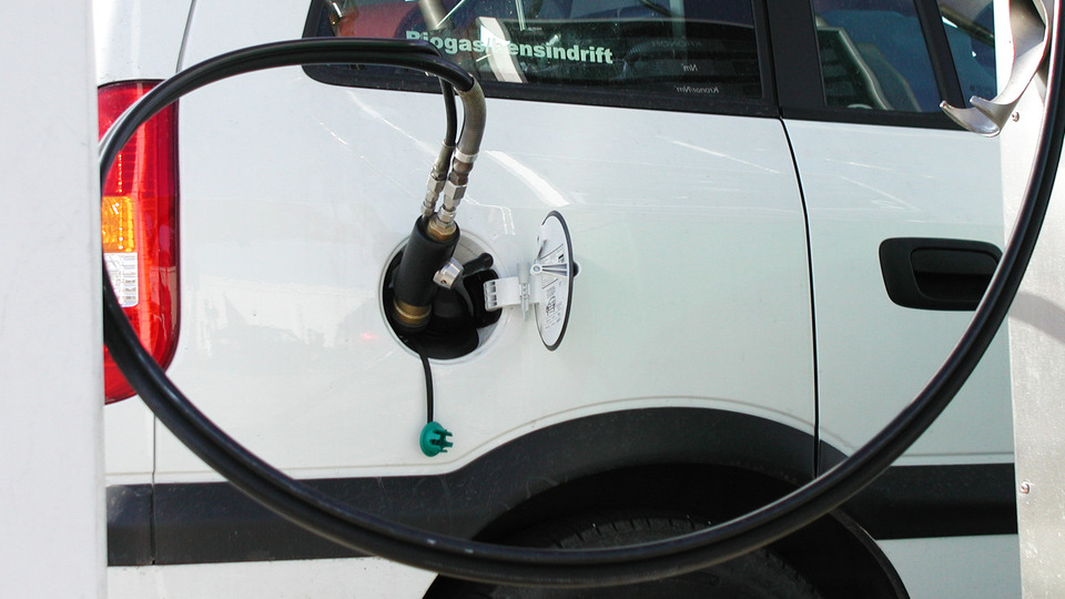 Closeup of a white car fueling biogas.