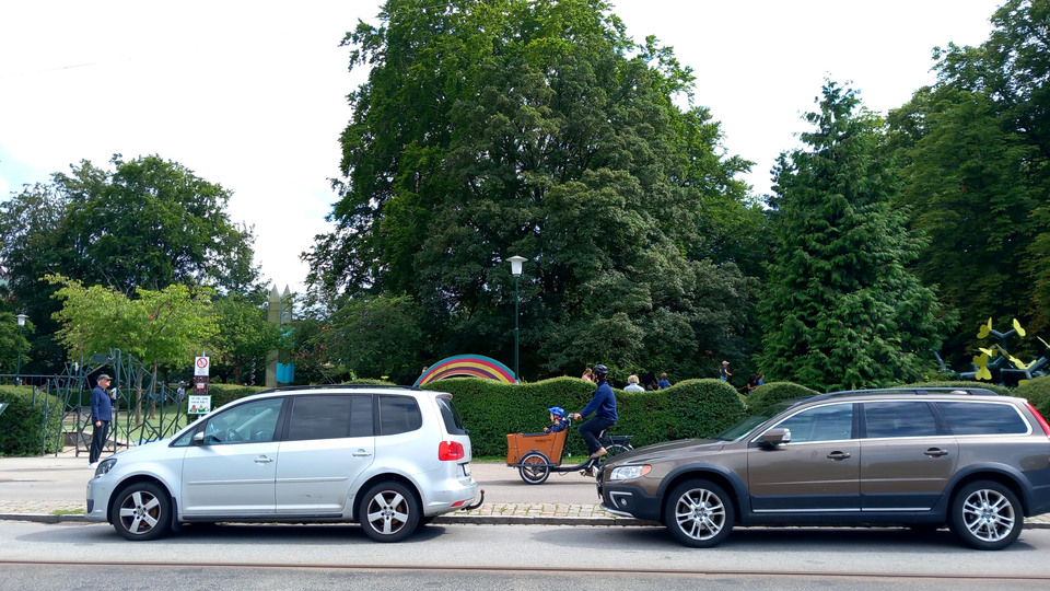Bilar parkerade bredvid cykelväg och lekpark i Malmö